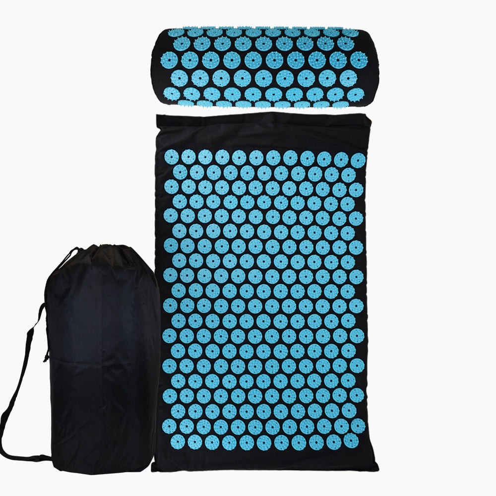 Flach ausgelegte schwarze Matte mit blauen runden Feldern, darüber Kissen, links Tasche