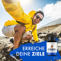 Thumbnail for OG-Energy-Gummies-Dose neben Mann in gelber Jacke auf felsigem Gelände mit Text „Erreiche deine Ziele“