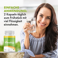 Thumbnail for Frau hält Glas Wasser neben Trimology Premium Dose und Anwendungstext zu 2 Kapseln