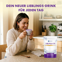 Thumbnail for Frau trinkt Ube Latte in heller Küche, daneben Provilea Nutrition Ube Pulver Beutel als Lieblingsdrink